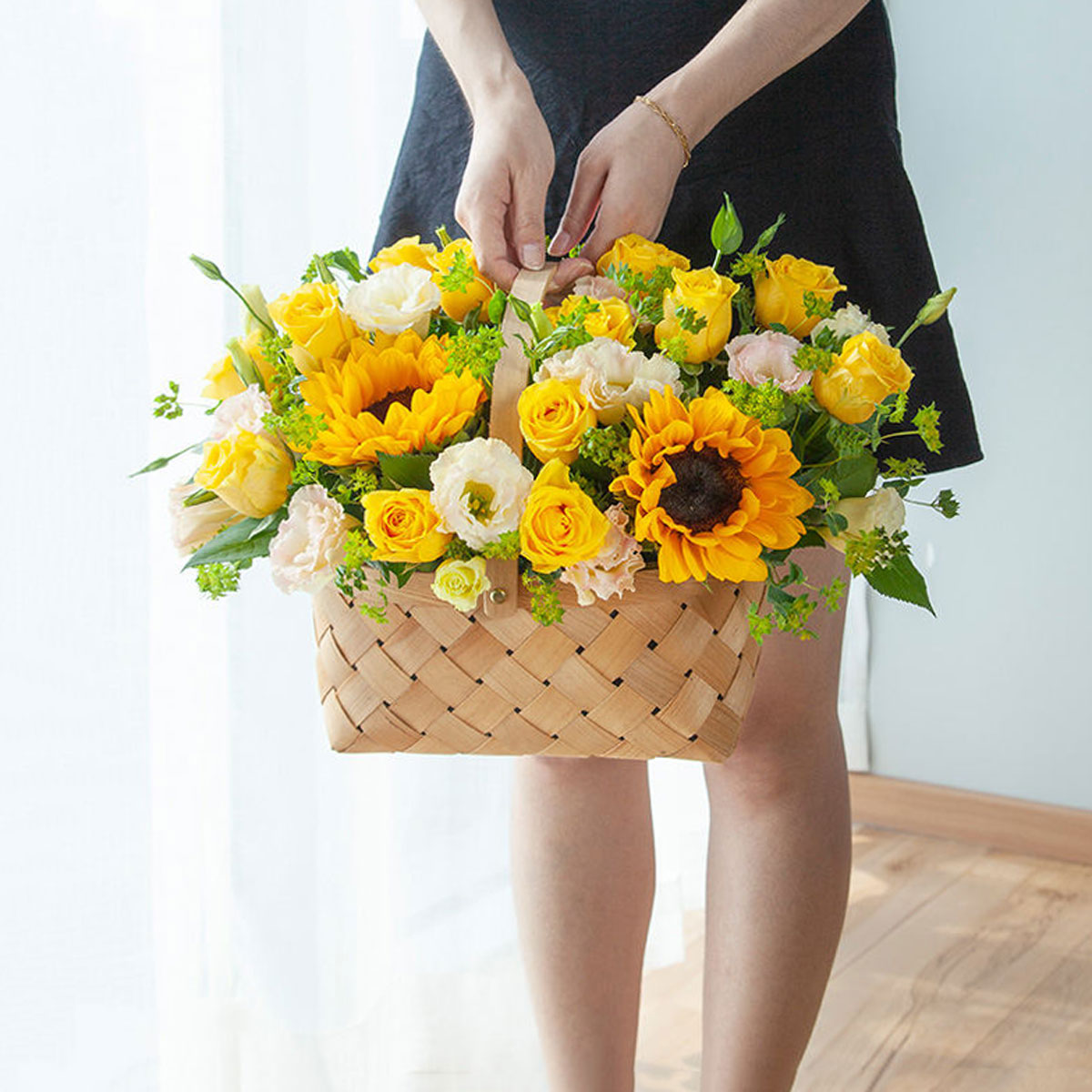 A woman holding a basket of beautiful fresh Sunflowers and Yellow Roses, delivered to her in China.